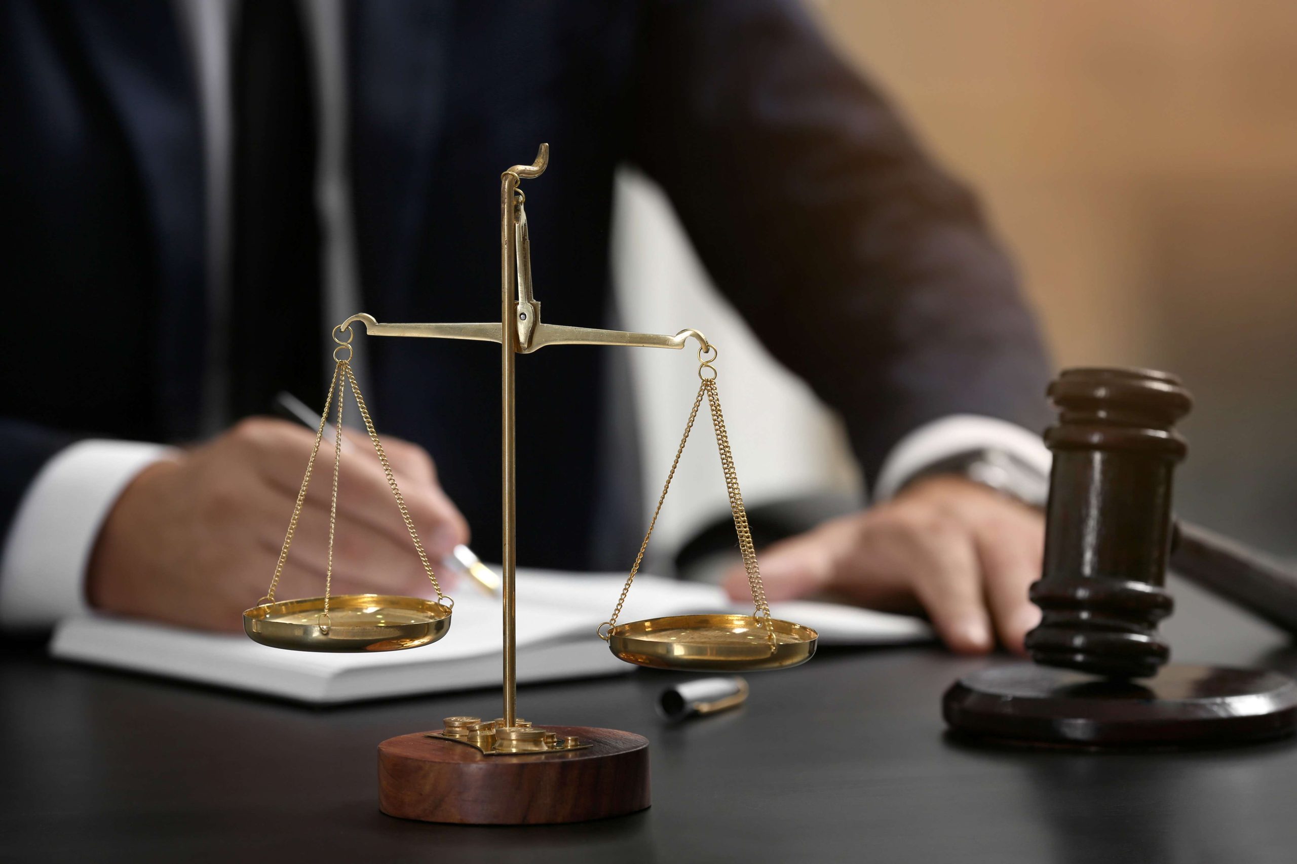 Scales of justice and judge gavel on table, closeup