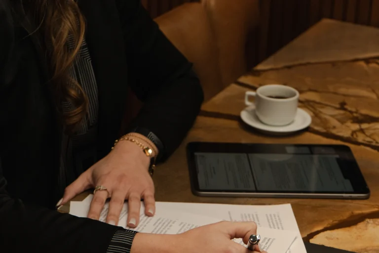 Servidora publica assinando requerimento administrativo sobre a mesa do escritorio